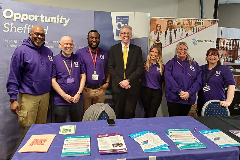 Opportunity Sheffield staff at an event. They are wearing purple branded Opportunity Sheffield tops.
