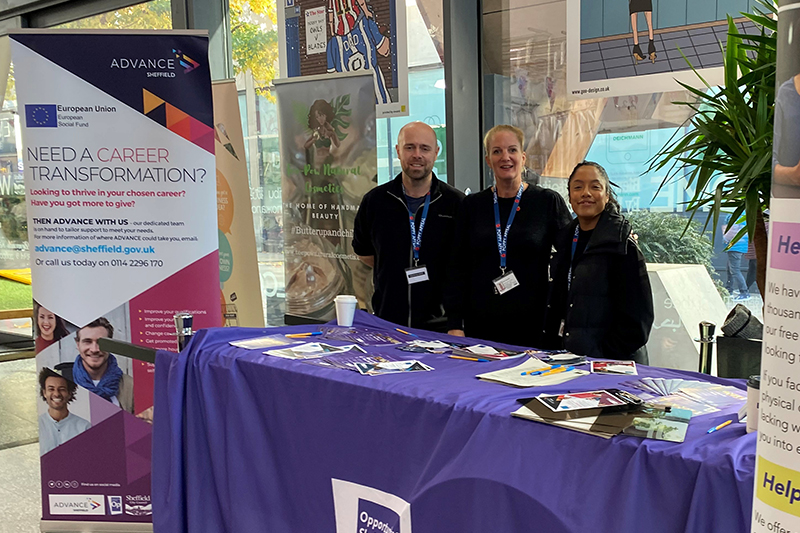 Group of people at a stall with purple Opportunity Sheffield branding