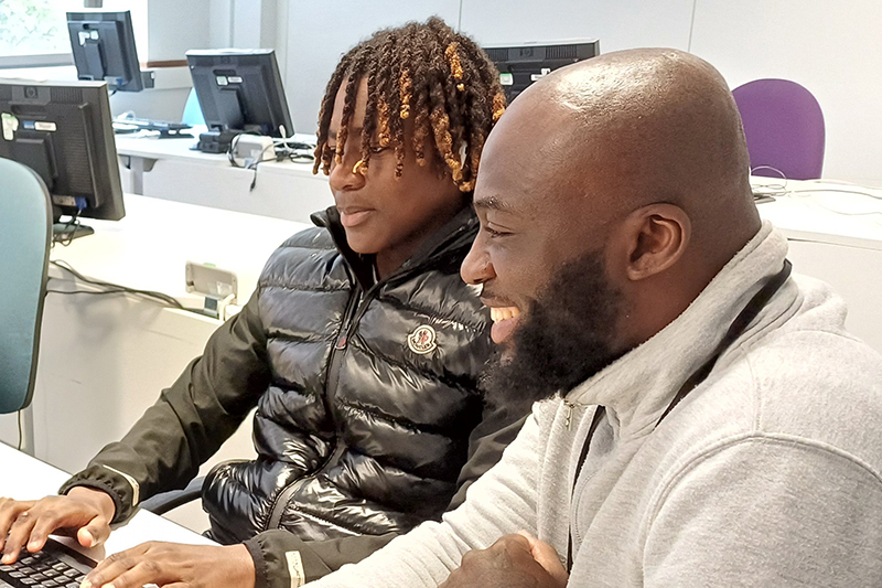 Two people sat using a computer