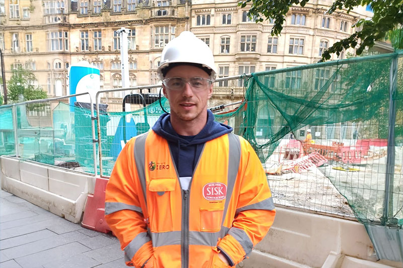 Construction worker stood onsite wearing hi vis vest and protective headgear