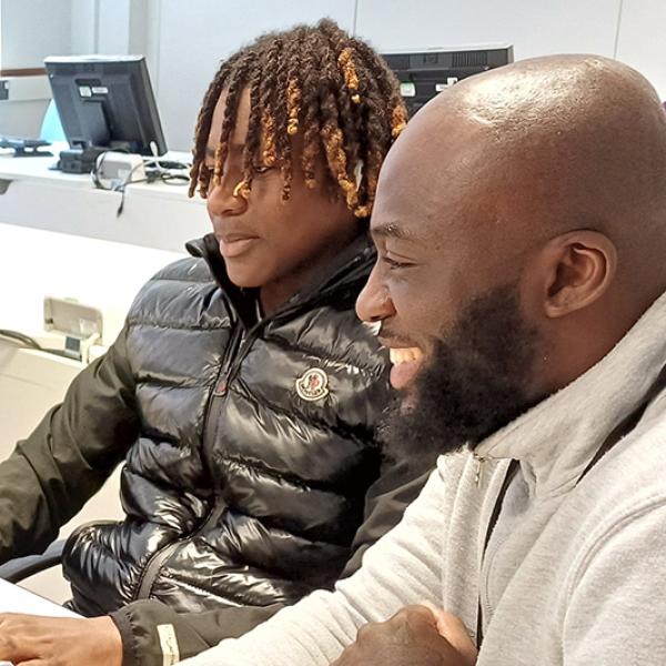 Two people sat using a computer